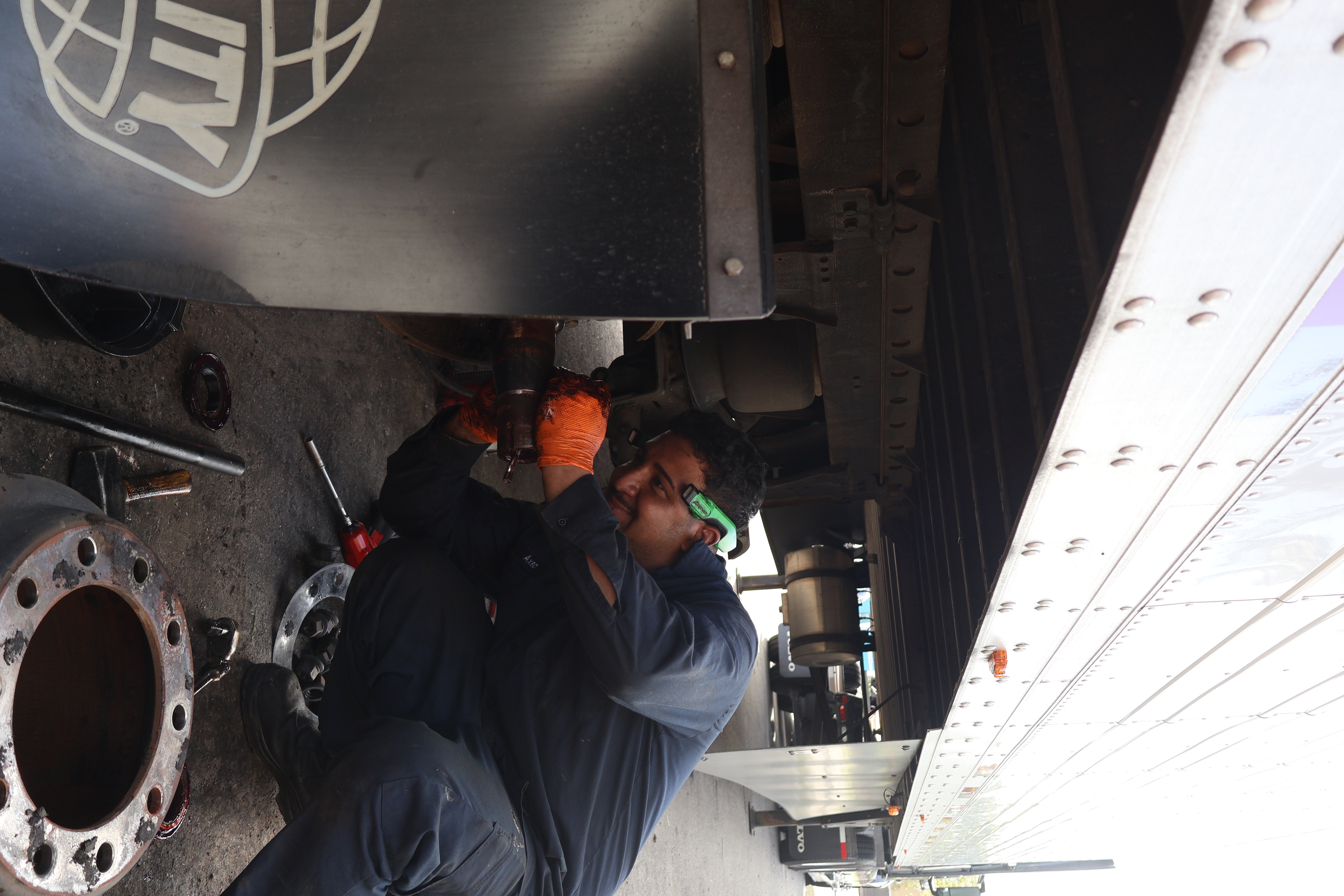 Technician performing undercarriage repair on semi trailer
